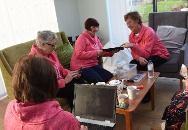 Residents at Bishop Ramsay Court enjoying a cup of tea and biscuits, while using their laptops and tablets.